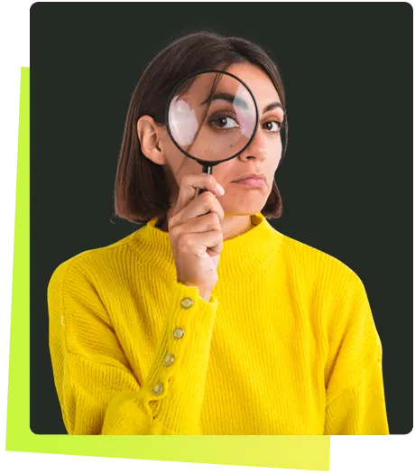 Woman in a yellow sweater looking through a magnifying glass